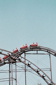 a red train going down the track on a roller coaster