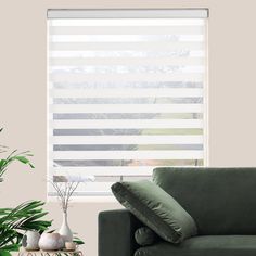 a living room filled with furniture and a window covered in blinds