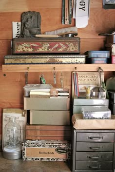 an assortment of boxes and other items in a room with wood paneling on the walls