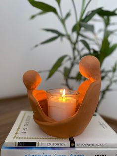 a candle sits on top of some books