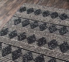 two black and white rugs sitting on top of a wooden floor