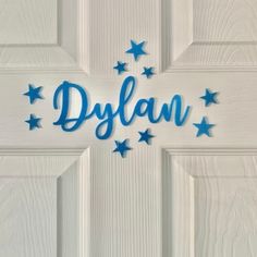 the word dylan written in blue on a white door with stars around it