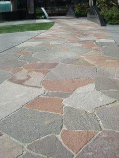 the walkway is made out of stone and has grass in the background