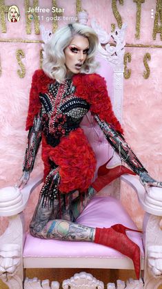 a woman sitting on top of a pink chair