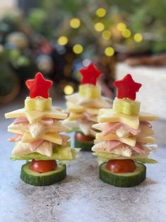 small sandwiches made to look like christmas trees on cucumbers with cheese and tomatoes