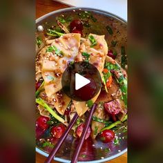 a bowl filled with food and chopsticks on top of a table