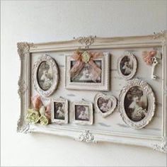 an ornate white frame with pictures and flowers on the front is hung above a wall