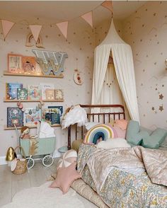 a child's bedroom with pink walls and gold stars on the ceiling is decorated in pastel colors