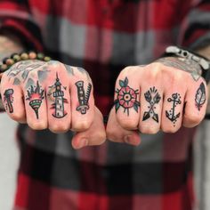 two men with tattoos on their hands are holding each other's fingers and pointing them at the camera