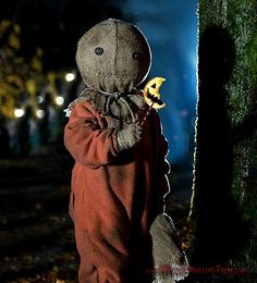 a stuffed animal is standing next to a tree with the words trick'r treat written on it