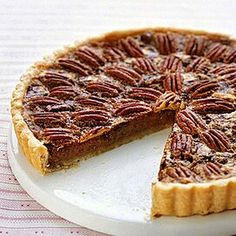 a pecan pie on a plate with one slice cut out and ready to be eaten