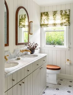 a white bathroom with two sinks and a mirror on the wall next to a toilet