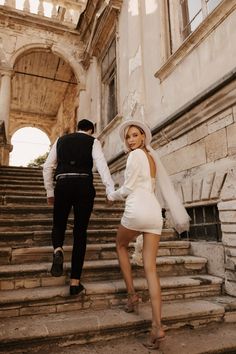 a man and woman walking down some steps