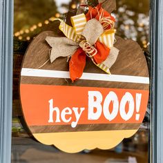 a sign that says hey boo hangs on the front door to someone's house