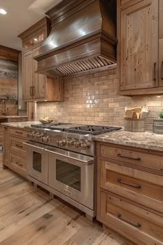 a kitchen with wooden cabinets and stainless steel stove top oven, range hood, and wood flooring