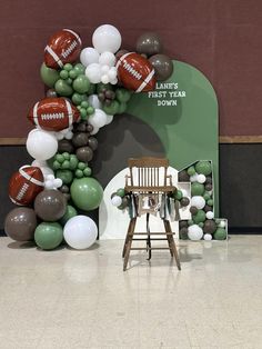 a balloon arch with footballs and balloons on it