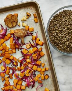 chopped vegetables on a baking sheet next to a bowl of lentils