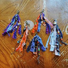 several scarves are laid out on a wooden floor with beads and chains hanging from them