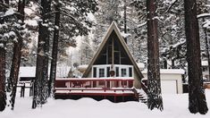 a cabin in the woods with snow on the ground