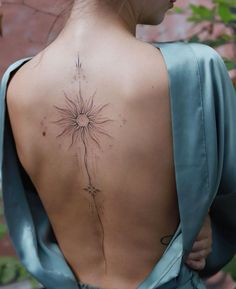 the back of a woman's neck with a dandelion tattoo on it