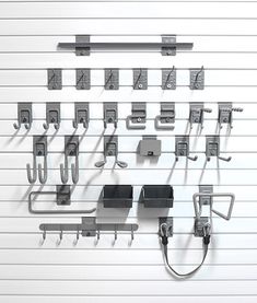 a bunch of metal objects hanging on a wall with hooks and clips attached to them