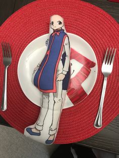 a plate with a fork and knife on it next to a red place mat that has an image of a man