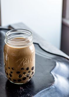 a glass jar filled with liquid sitting on top of a table