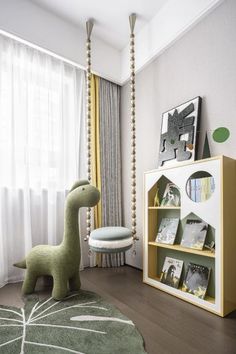 a child's room with a green dinosaur toy in front of a bookcase