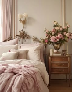 there is a bed with pink sheets and flowers on the headboard in this room