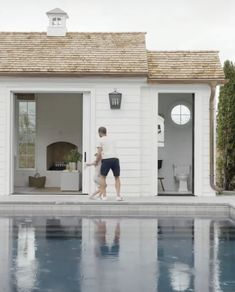 a man and woman walking into a pool house