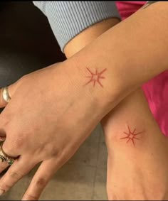 two people with matching tattoos on their hands and one is holding the other's hand