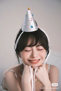 a woman wearing a party hat with her eyes closed