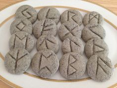 some cookies are on a white plate and have letters drawn on them in the shape of arrows