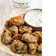 some fried food is on a plate next to a bowl of ranch dressing