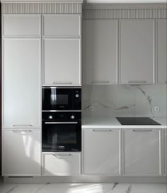 an empty kitchen with white cabinets and marble counter tops, along with a black stove top oven