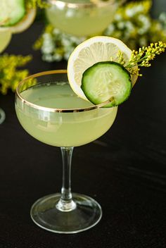 the cucumber is garnished with a slice of lemon and served in coupe glasses