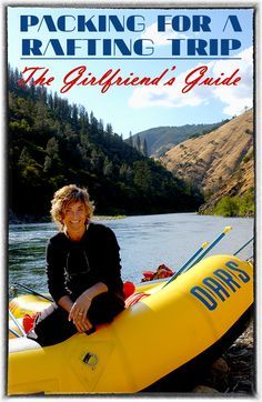 a woman sitting on top of a yellow raft next to a river with mountains in the background