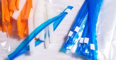 several different colored toothbrushes in plastic bags next to each other on a table