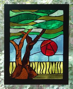 a stained glass window with a tree and red umbrella