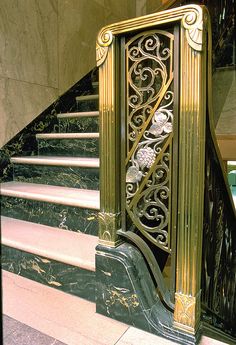 an ornate gold and black staircase with marble steps