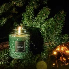 a green candle sitting on top of a christmas tree