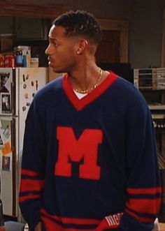 the young man is talking to his friend in front of an open refrigerator with magnets on it