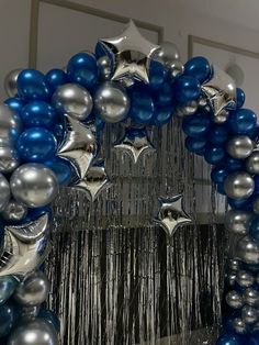 a blue and silver balloon arch with stars on it