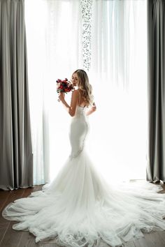 a woman in a wedding dress holding flowers