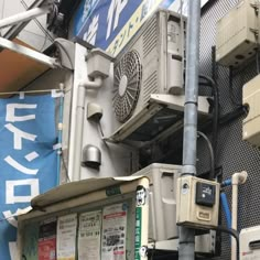 an air conditioner mounted on the side of a building next to a street sign