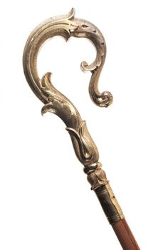 an ornately carved cane with a wooden handle on it's end, in the shape of a snake