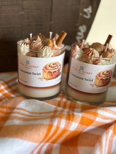 two jars filled with cinnamon swirl desserts on top of a checkered table cloth