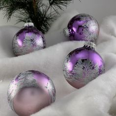 purple and silver christmas ornaments on white fur