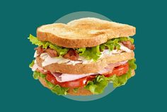 a sandwich with meat, lettuce and tomato on it in front of a blue background