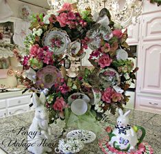 a table topped with plates and flowers on top of a kitchen counter next to a vase filled with flowers